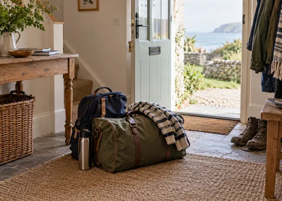 Travel bags just inside a cottage entrance.