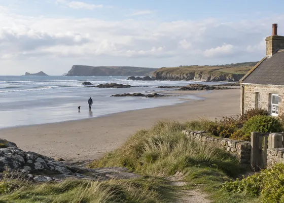 Wide British beach with a distant person walking.