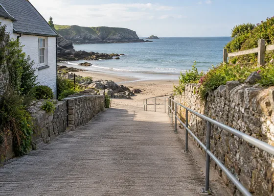 Sloping paved access ramp down to a beach.