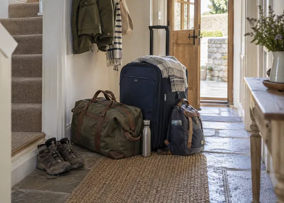 Packed bags arranged neatly in a cottage hallway.