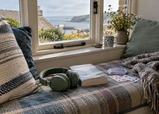 Headphones book and cards on a window seat.